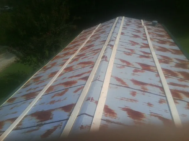 Rusted metal roof panels with new wood purlins before replacement — Storm Damage Roof Repair in Lacota by Roofing Brothers