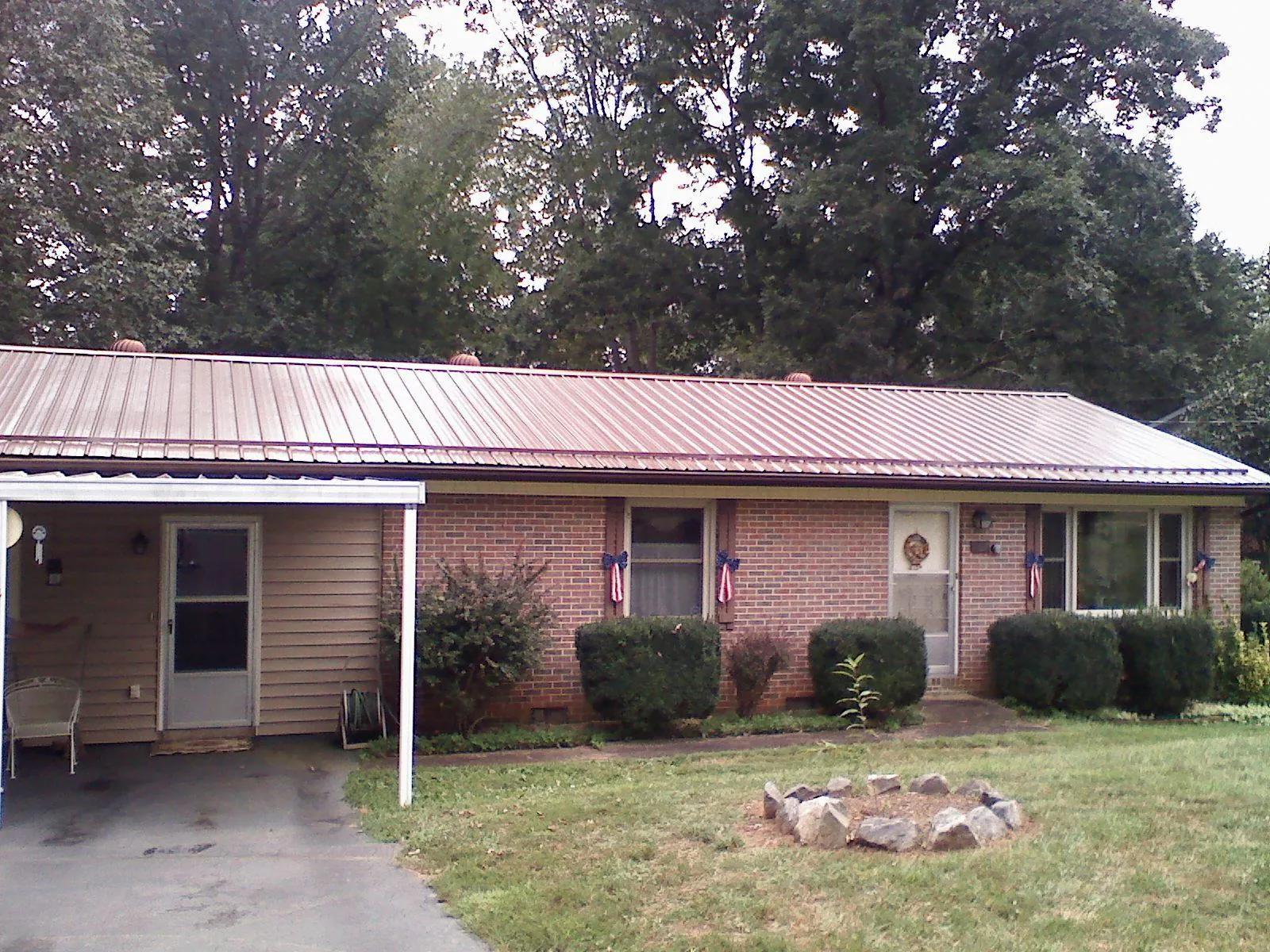 Bronze metal roof and carport on a brick ranch home — Roof Repair work by our crew in Lacota